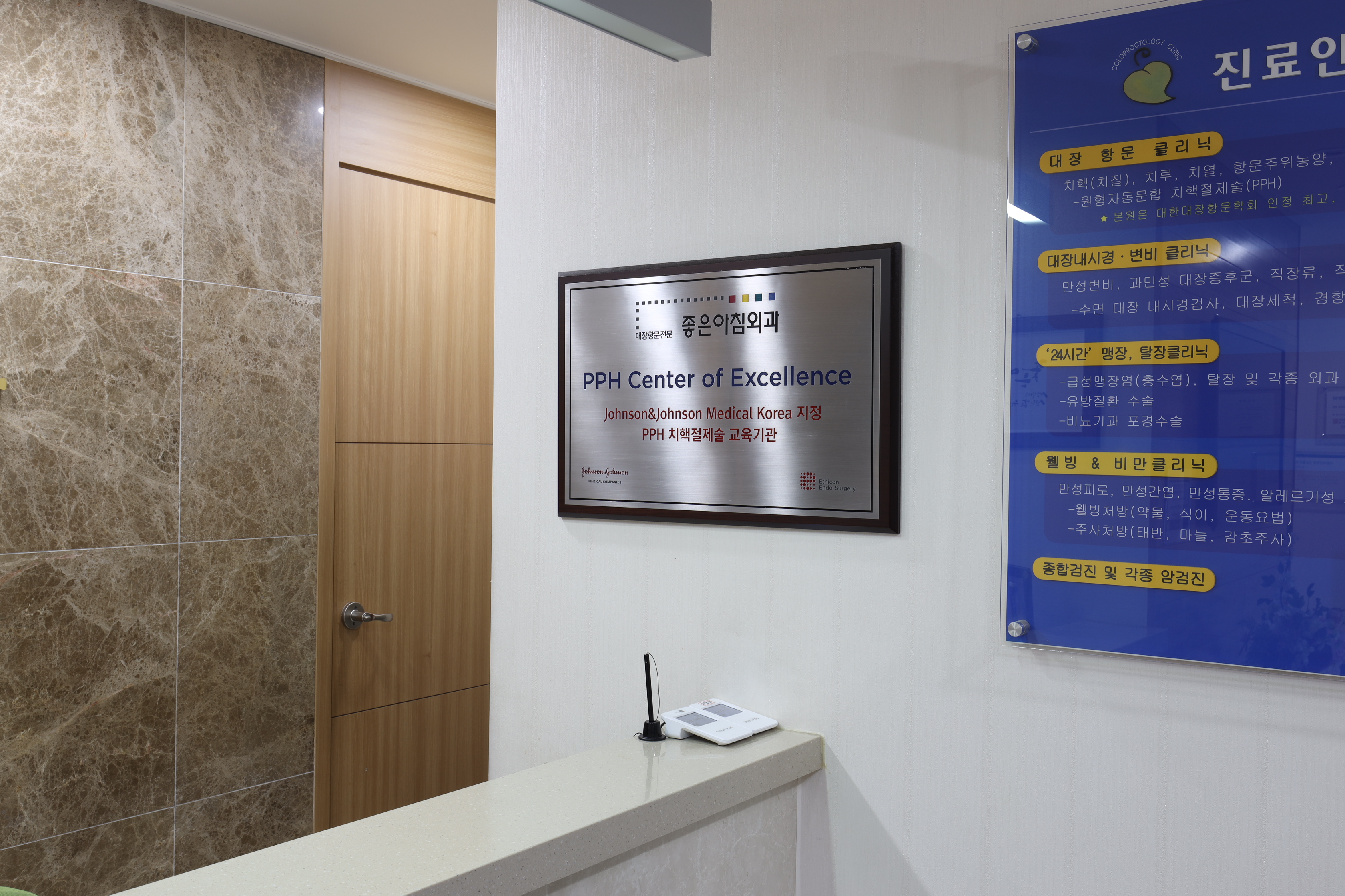 좋은아침외과 접수 공간에 설치된 PPH Center of Excellence 현판과 진료 안내판